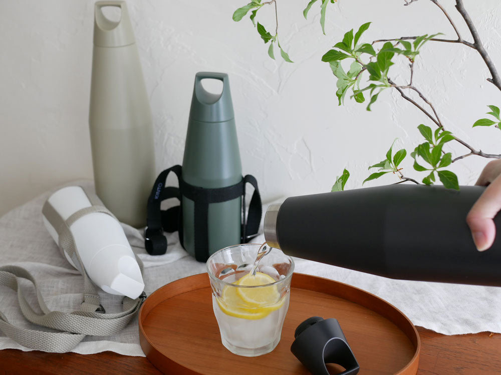 キントー製トレイルタンブラー580mlと調整可能な専用ストラップが並べられた画像。ステンレススチールとポリプロピレン素材を使用したシンプルなデザイン。