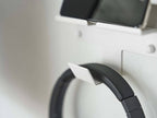 スマートフォンとヘッドホンを収納するシルバー製のウォールマウントホルダー