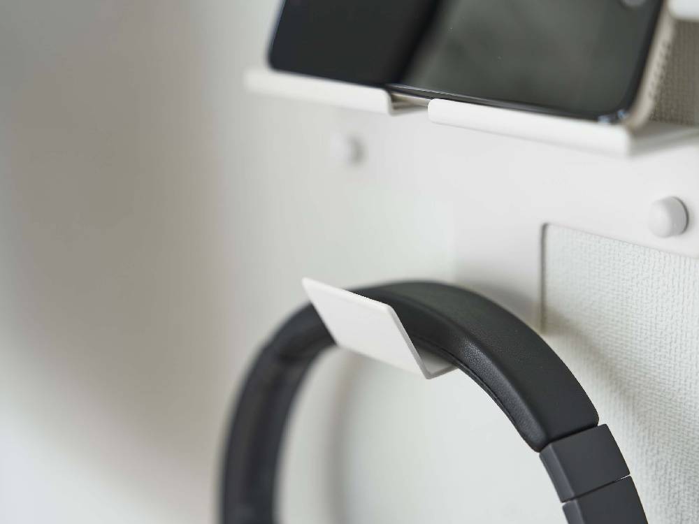 スマートフォンとヘッドホンを収納するシルバー製のウォールマウントホルダー