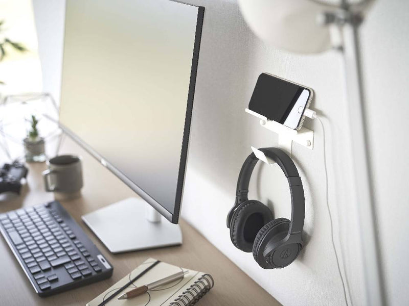 スチール製の壁掛けスマートフォン＆ヘッドホンホルダーがデスク上に設置されている様子