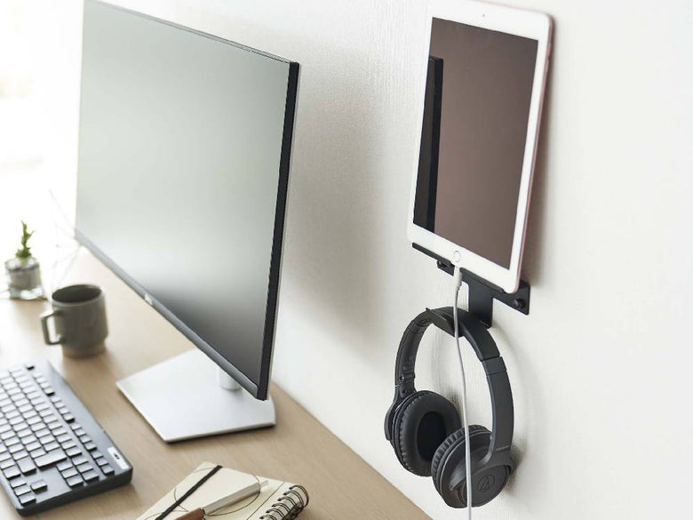 壁に取り付けられた【smart/スマート】ウォールスマートフォン＆ヘッドホンホルダーが、スマートフォンとヘッドホンを整然と収納している様子