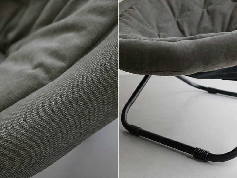 グレーの2wayフォールディングチェアがリビングルームの木製フローリング上に配置され、デイベッドやソファーとして快適に使用できる様子