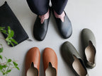 レプリエノイエルッツのブラウンとグレーの合成皮革スリッポンL。足元と足首を写した静物写真
