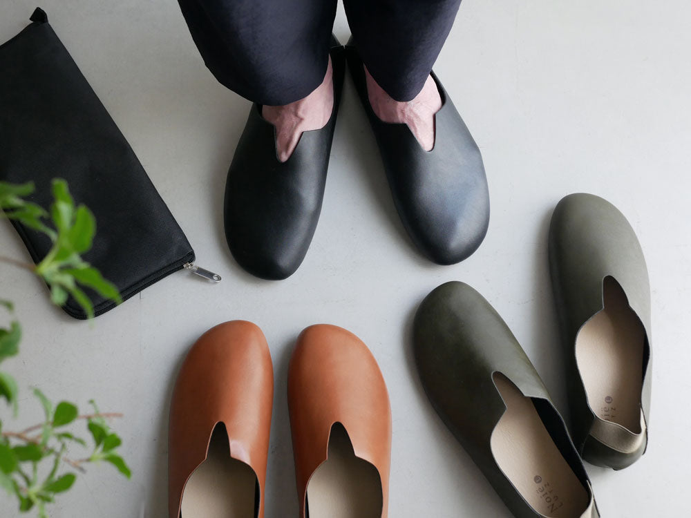 レプリエノイエルッツのブラウンとグレーの合成皮革スリッポンL。足元と足首を写した静物写真