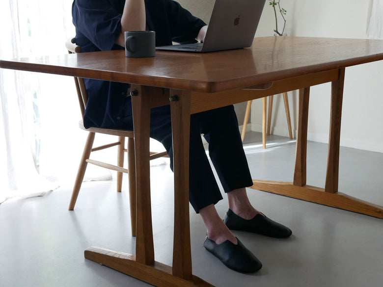 木製のデスクと椅子の上に置かれたレプリエノイエルッツ携帯スリッポンL