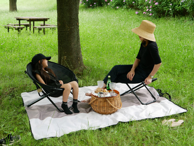 庭の芝生に置かれた【Comore Sun】2wayフォールディングチェアとオットマンのセット、屋外で快適に使用できるデザイン