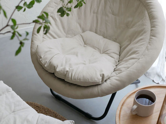 Comore Sunのグレー2wayフォールディングチェア用キャンバスクッションが木製フロアのリビングルームに配置され、快適なインテリアを演出している