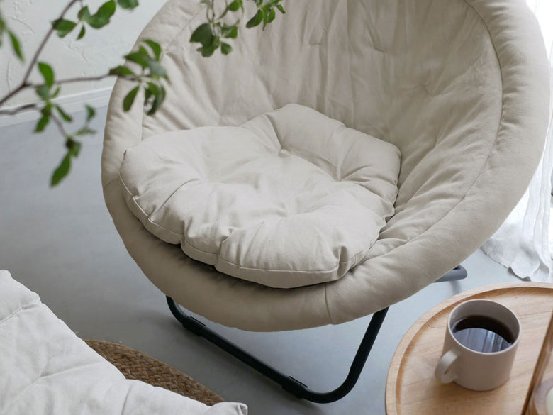 Comore Sunのグレー2wayフォールディングチェア用キャンバスクッションが木製フロアのリビングルームに配置され、快適なインテリアを演出している