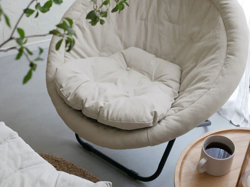 Comore Sunのグレー2wayフォールディングチェア用キャンバスクッションが木製フロアのリビングルームに配置され、快適なインテリアを演出している