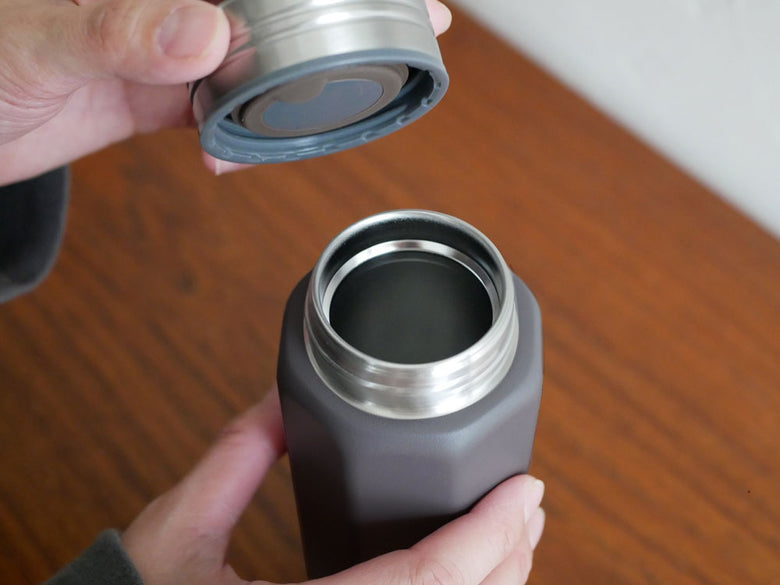 シービージャパンのholmsオクタボトル ロングショルダー、ステンレス製の銀色シリンダー型水筒で、プラスチック製蓋が付いた画像