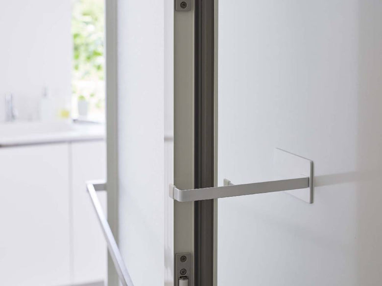 タワーのマグネット浴室扉ストッパーが浴室のドアに取り付けられている様子