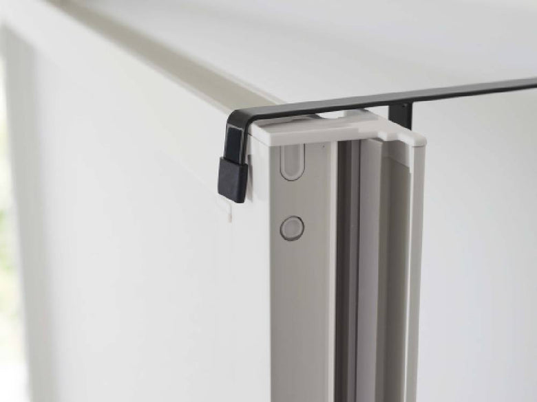 浴室のアルミ製スライディングガラス扉に「タワー」マグネット浴室扉ストッパーが取り付けられ、床やヒンジが見える様子。