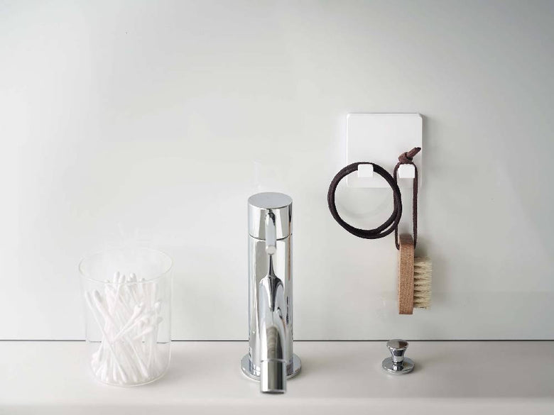 銀色のアルミニウム製MISTフィルムフック シェーバーホルダーがバスルームの壁に取り付けられている様子