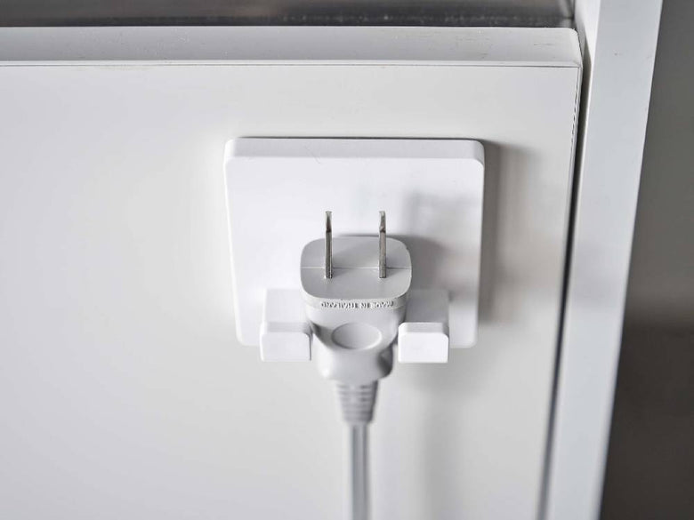 壁に取り付けられた【MIST/ミスト】フィルムフック シェーバーホルダーと電源プラグおよびケーブル