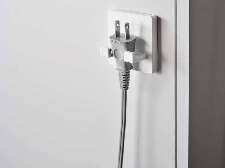 ミストフィルムフック シェーバーホルダーが光沢のある壁面に取り付けられている様子。ABS樹脂製のホルダーとポリカーボネート製のフィルムフックがシェーバーをしっかりとホールドしています