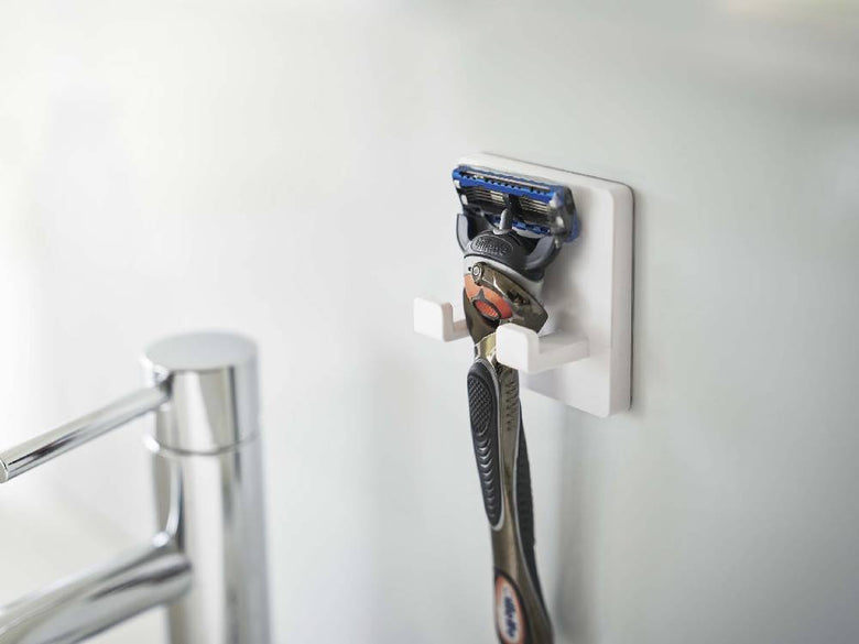 【MIST/ミスト】フィルムフック シェーバーホルダーの製品画像。幅6cmのABS樹脂本体にポリカーボネート製フィルムフックが取り付けられており、シェーバーを掛けて壁面に簡単に設置可能。