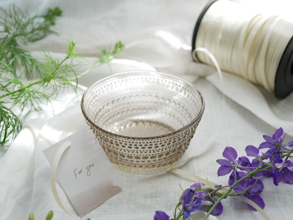 シルバーのパターンが特徴的な自然素材の籠に、フィンランド製イッタラの無鉛ガラスカステヘルミボウルが収納されている様子