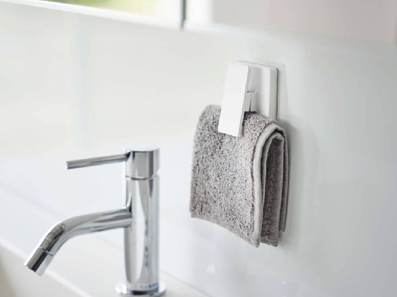 洗面台に設置された蛇口、ソープディスペンサー、タオルスタンドが配置されたバスルームの様子