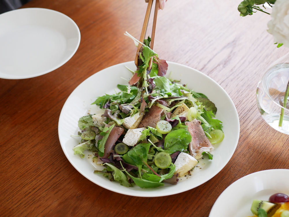 イッタラ製ティーマプレートに盛られたサラダと食卓用食器の写真