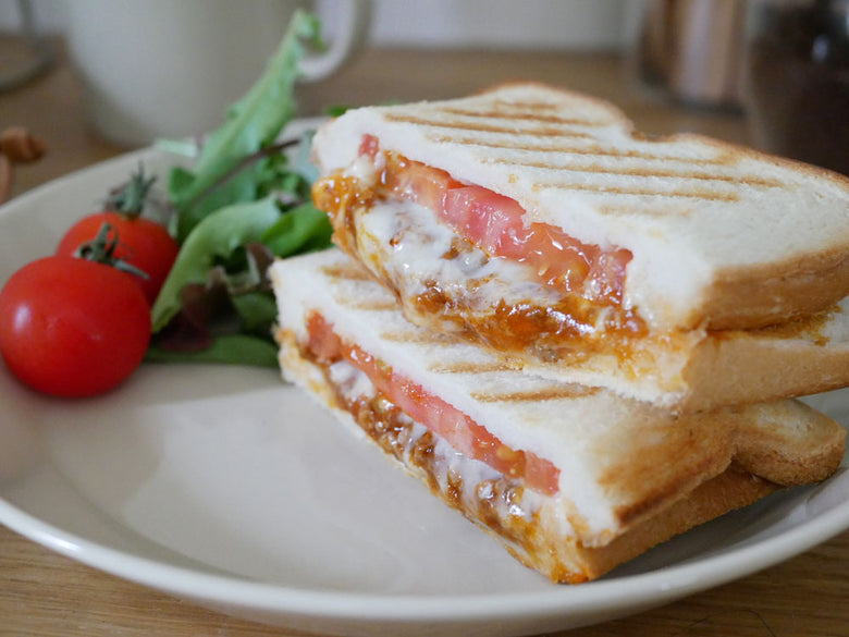 チーズを挟んだホットサンドとテーブルウェアが朝食として並べられている様子