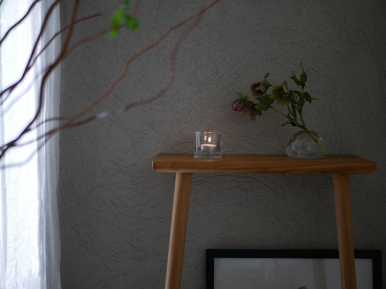 無鉛ガラス製イッタラキビキャンドルホルダーが木目のテーブルの上に置かれ、観葉植物と共にディスプレイされています。