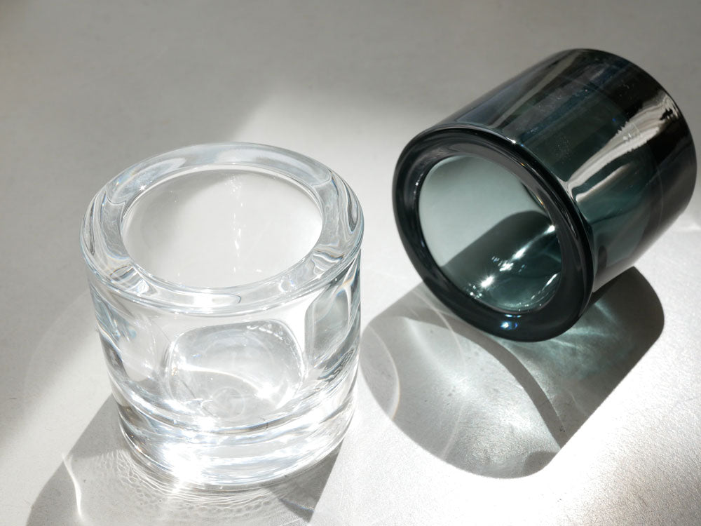 フィンランド産無鉛ガラス製のシルバー色キビキャンドルホルダーが円柱形で、影とともに静物として撮影されています。