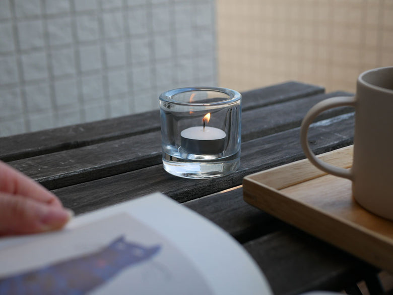 iittalaのフィンランド製無鉛ガラスキビ キャンドルホルダーに灯されたキャンドルとガラス食器が並ぶテーブル