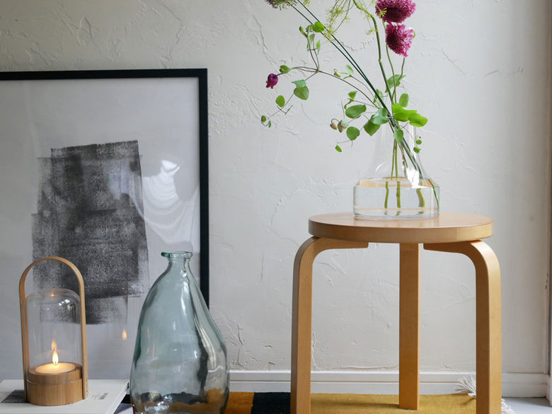 BOB CRAFTのソーダガラス製ファゴット花瓶が木製フローリングと植物、ランプと共に室内に飾られています