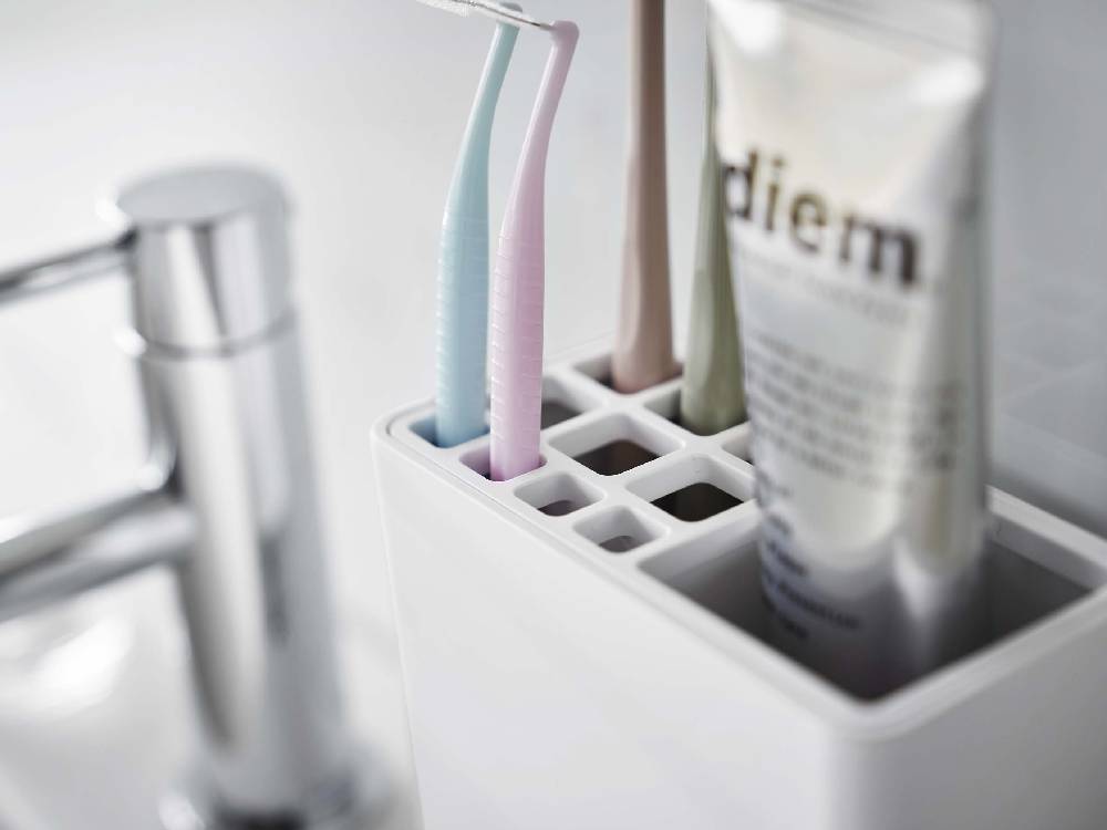 MIST/ミスト フィルムフック 歯ブラシスタンドがバスルームの光沢のある壁面に設置され、歯ブラシやソープディスペンサーを整理しているプラスチック製の家庭用品