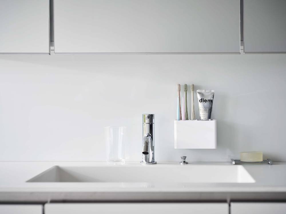 MIST/ミストブランドのフィルムフック付き歯ブラシスタンド。白いABS樹脂製の容器にポリカーボネート製フックが2つ付いており、浴室の壁面に簡単に取り付けられるデザイン。