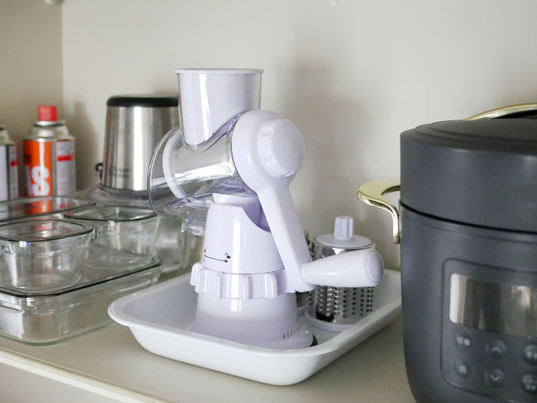 クレバースライサー本体とスライス・すりおろし用ステンレスドラムが並んだキッチン家電の画像