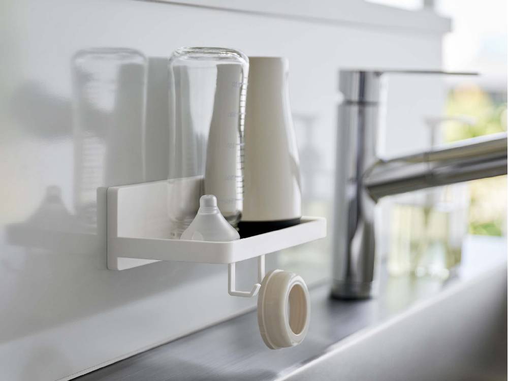 洗面台横の壁に取り付けられたシルバーのプラスチック製【MIST/ミスト】フィルムフック トレー W18が洗面用品を整理している様子