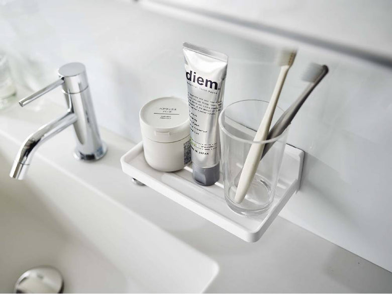 バスルームのシンク周りに設置された【MIST/ミスト】フィルムフック トレー W18。蛇口やソープディスペンサーなどの家庭用品が整理されています。