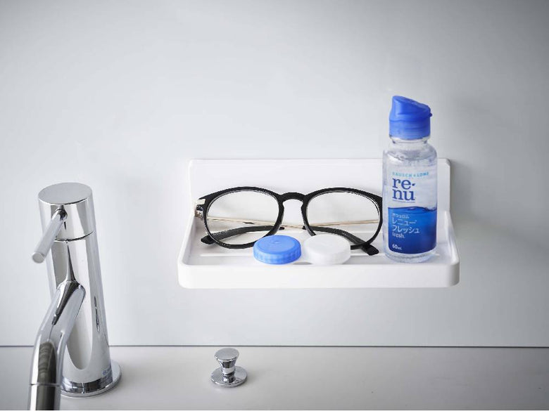 浴室の壁に設置されたMISTフィルムフックトレーW18に、ソープディスペンサーやプラスチックボトルが掛けられている様子