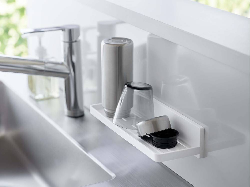 シルバーのタップとシンクが置かれたキッチンカウンタートップ上に設置されたフィルムフックトレー