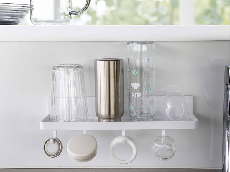 キッチンの棚に設置された【MIST/ミスト】フィルムフック トレー W30が、瓶やグラスなどの食器類を整理している様子