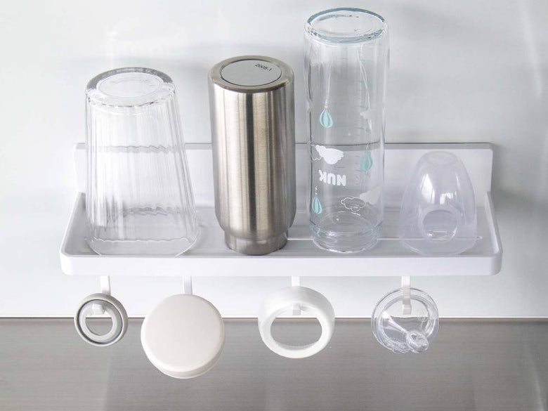 キッチンの棚に設置された【MIST/ミスト】フィルムフック トレー W30に、プラスチックや銀色の調理器具が整理されています