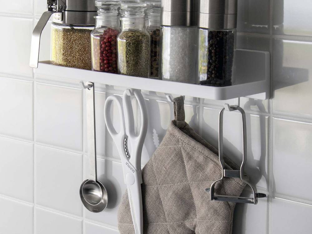 キッチンの棚に設置された【MIST/ミスト】フィルムフック トレー W30と、上に置かれた瓶や調理器具が見える様子