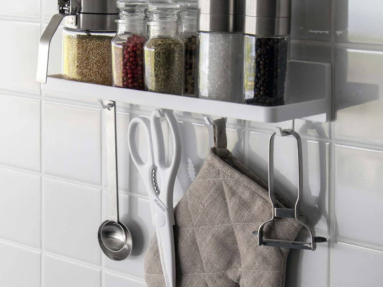 キッチンの棚に設置された【MIST/ミスト】フィルムフック トレー W30と、上に置かれた瓶や調理器具が見える様子