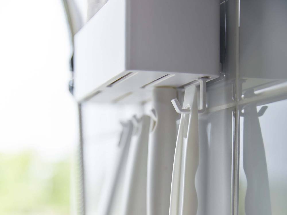 シルバーのウィンドウトリートメントが掛かったグレーのカーテン付きガラス窓