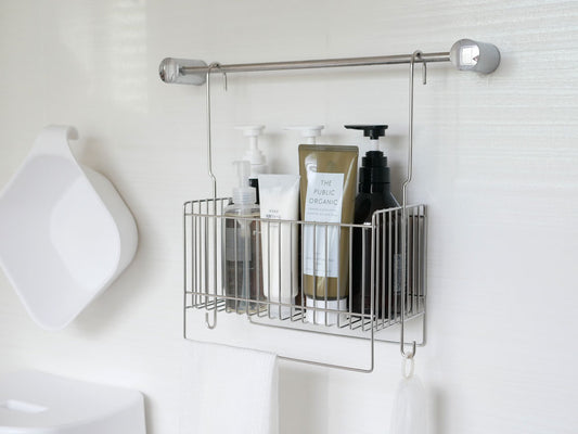 バスルームのシンク上に掛けられた18-8ステンレス製の引っかけ式バスケットと、ボトルや石鹸ディスペンサー、歯ブラシホルダーが整然と配置されている様子