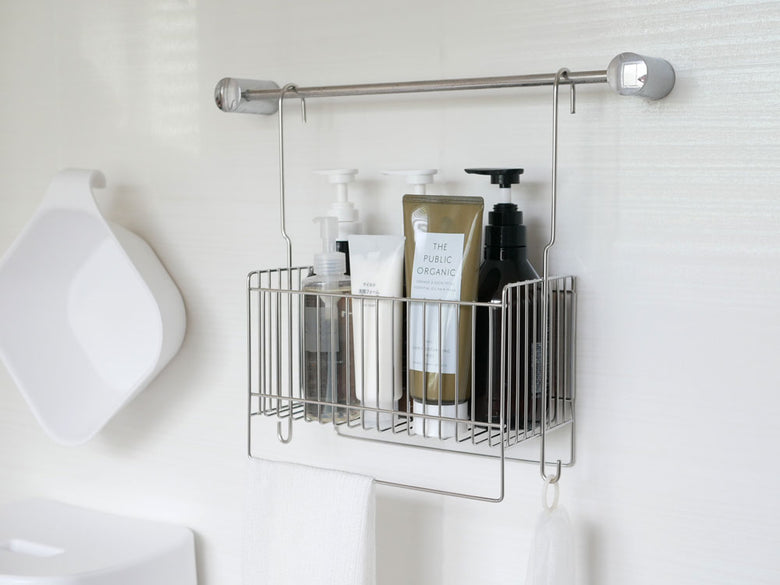 バスルームのシンク上に掛けられた18-8ステンレス製の引っかけ式バスケットと、ボトルや石鹸ディスペンサー、歯ブラシホルダーが整然と配置されている様子