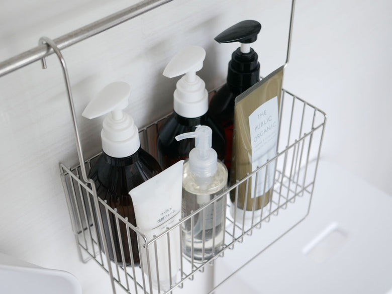 Hinata Lifeの連結可能な18-8ステンレス製引っ掛けお風呂バスケットが浴室のタオルバーに取り付けられ、ボトルやタオルを整理しています。