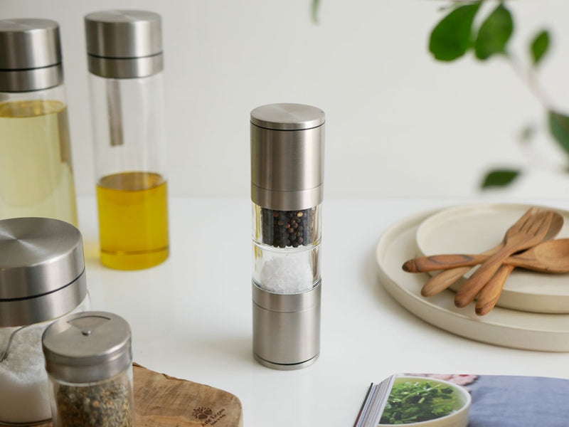 SALUS/セイラスのツインソルト＆ペッパーミル。ステンレス製の塩と胡椒用ミルがガラス瓶に収められ、蓋付きのシリンダー型デザイン。