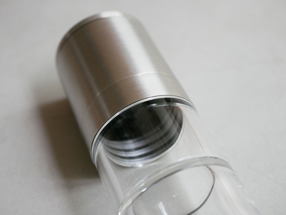 SALUS/セイラスのツインソルト＆ペッパーミル。18-8ステンレスとアルミニウム製のシリンダー形状で、銀色の金属部分と透明なアクリルパーツが調和したデザイン。セラミック製の挽き刃を備えています。