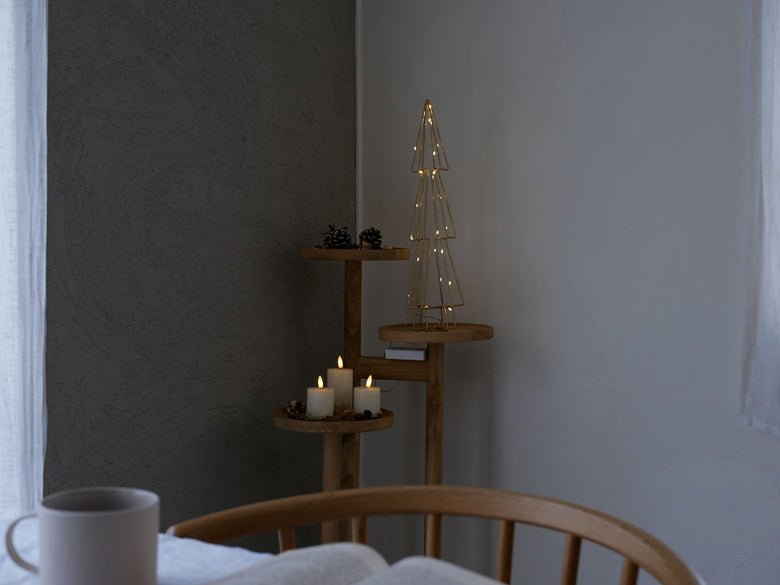 サンフラワーラタンのチークステップトレイテーブルに銀色のランプと花瓶を配置した静物写真