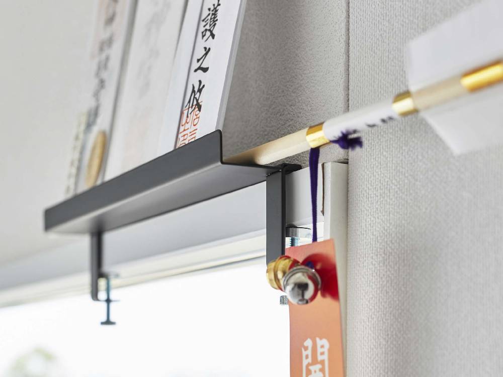 Yamazakiタワーブランドの鴨居上神札スタンドが棚やパイプ、オフィス用品と共に配置されている様子