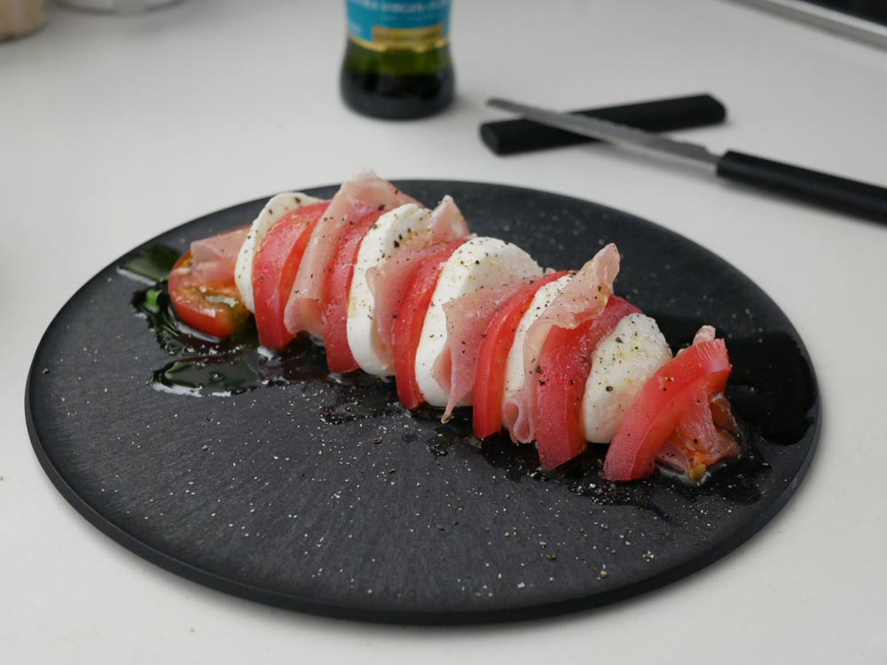 日本製SPS樹脂製チョップレートまな板お皿に、野菜やフィンガーフードが盛られた調理シーン