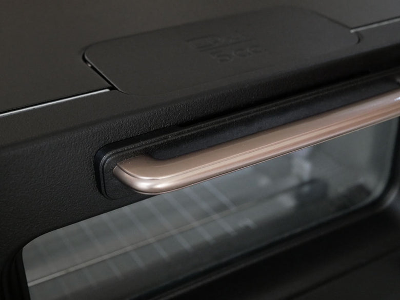 BALMUDA（バルミューダ）The Toaster Proがキッチンカウンター上に配置されている様子。スタイリッシュなデザインのトースターが家庭用電化製品として映し出されています。