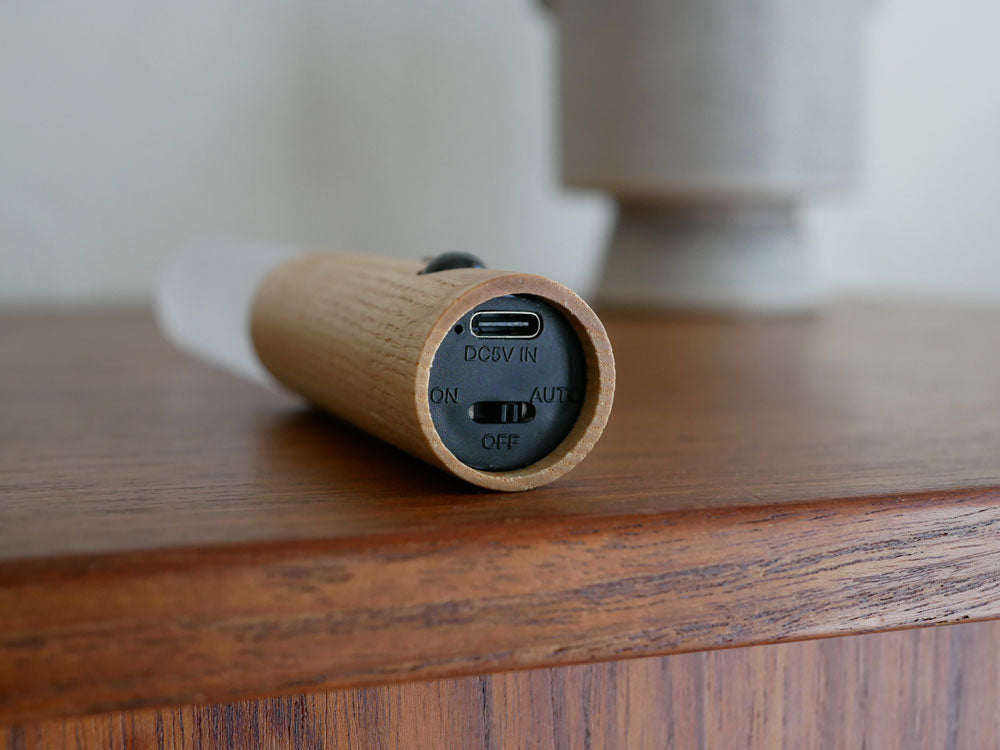 木製とアクリル製のオプト スティックセンサーライトが電気ケーブルとともに壁に取り付けられている様子